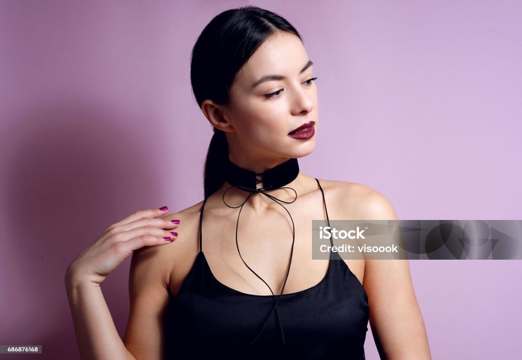 Fashion woman sensual lips with black choker bow accessory. Fashion young woman portrait sensual dark lips with black choker necklace bow accessory. Jewelry Stock Photo