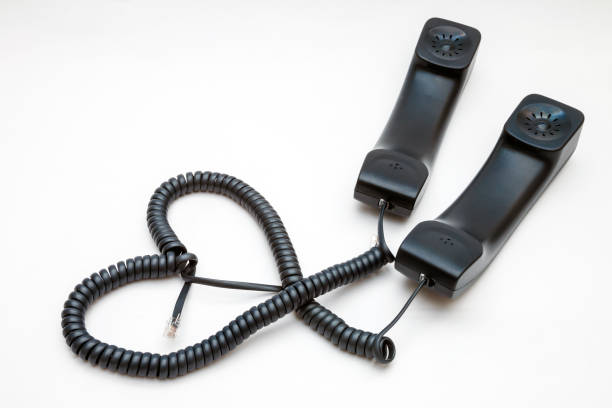 Two handsets with wires in the form of a heart. Love concept