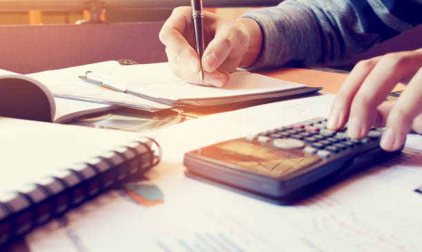 istock Young woman writing make note and doing calculate finance at home office. 686880482