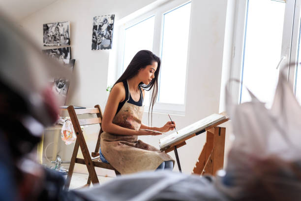 Prifile view of female painter working in her studio