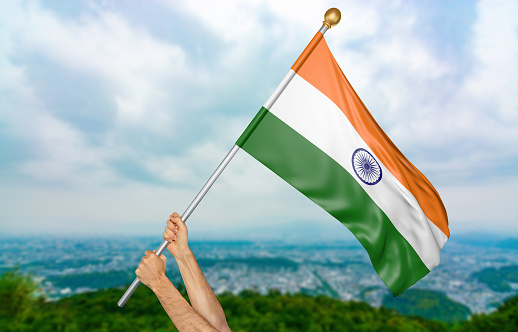 Man holding the national flag of India high in the air. The flag and pole have been realistically 3D rendered.
