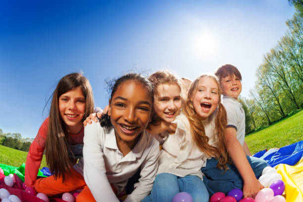 istock Kids sitting on mat surrounded by colorful balls 686889850