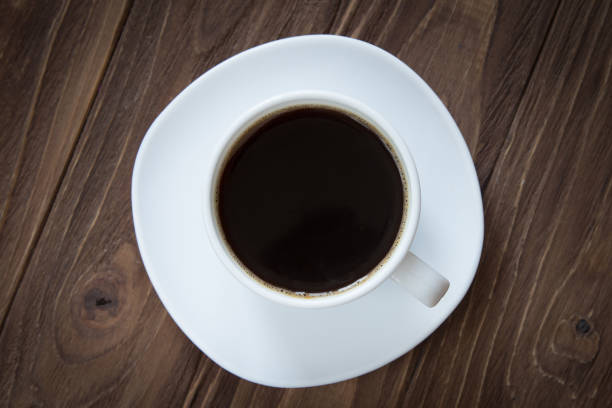 istock Cup of coffee on brown wooden background top view 686900510