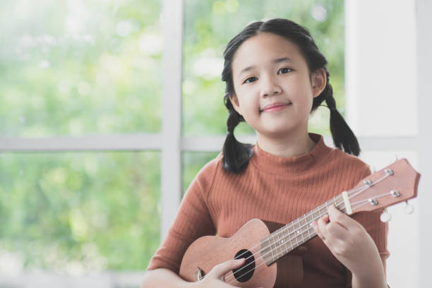 istock Beautiful Asian girl playing ukulele 686904990