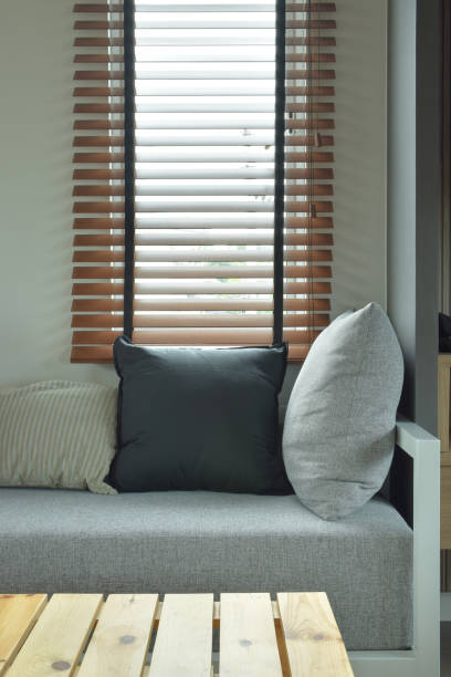 istock Wooden table with gray color cushion and pillows next to window 686917600