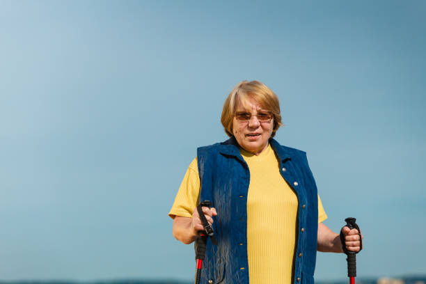 istock Senior woman practicing nordic walking on beach 686929486
