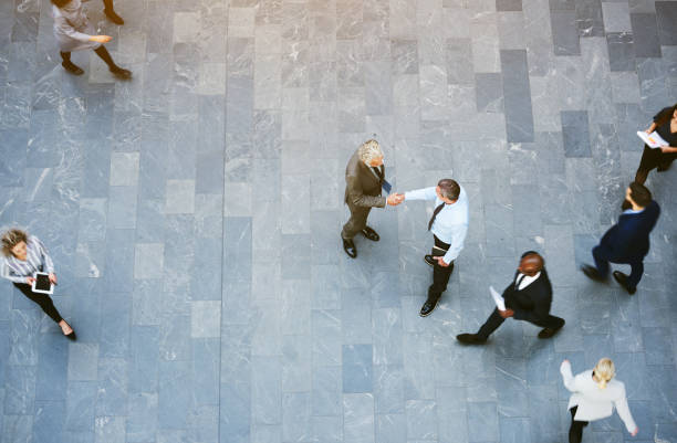 istock Adult office workers shaking hands in crowded hall 686942370