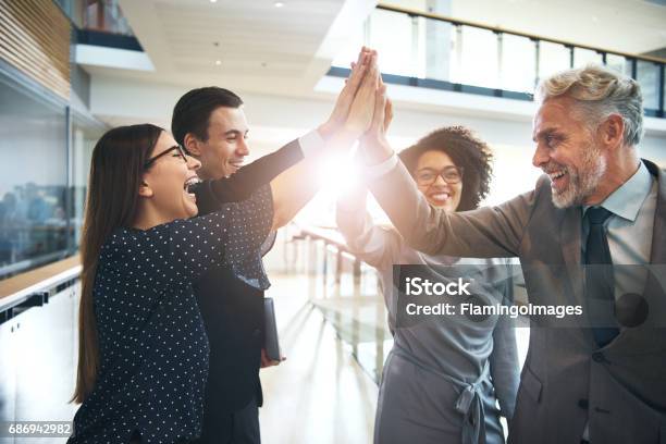 Foto de Rindo Equipe Multiétnica Dando Cinco No Escritório e mais fotos de stock de High-five