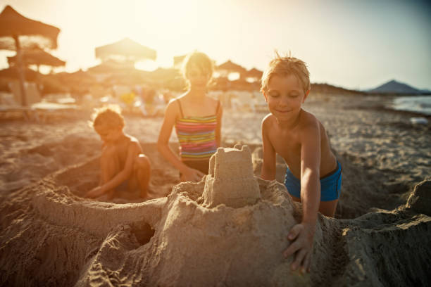 istock Brothers and sister are building sandcastles on a beach 686945466