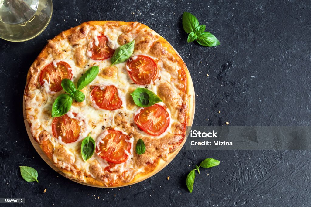 Pizza Margherita Pizza Margherita on black stone background, top view. Pizza Margarita with Tomatoes, Basil and Mozzarella Cheese close up. Pizza Stock Photo