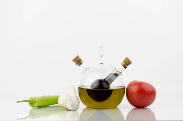 Olive Oil And Vinegar Bottle With Fresh Vegetables - Tomato, Pepper And Garlic On White Background With Reflection