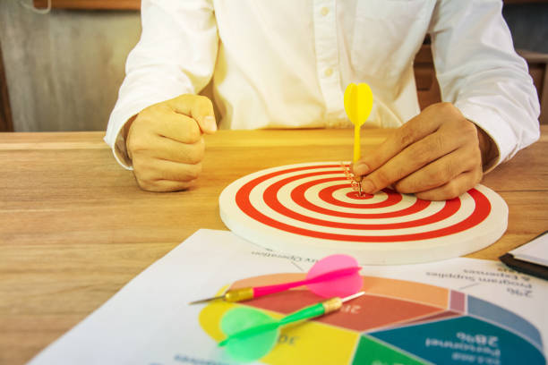 istock Business Man hand holding a target with darts hitting the center 686953474