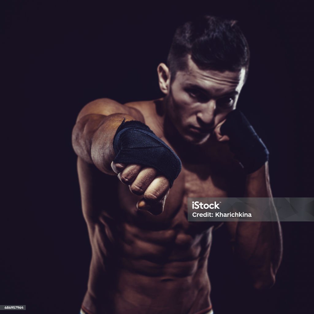 MMA Fighter Preparing Bandages For Training. Dark background MMA Fighter Preparing Bandages For Training. Dark background. Mixed Martial Arts Stock Photo