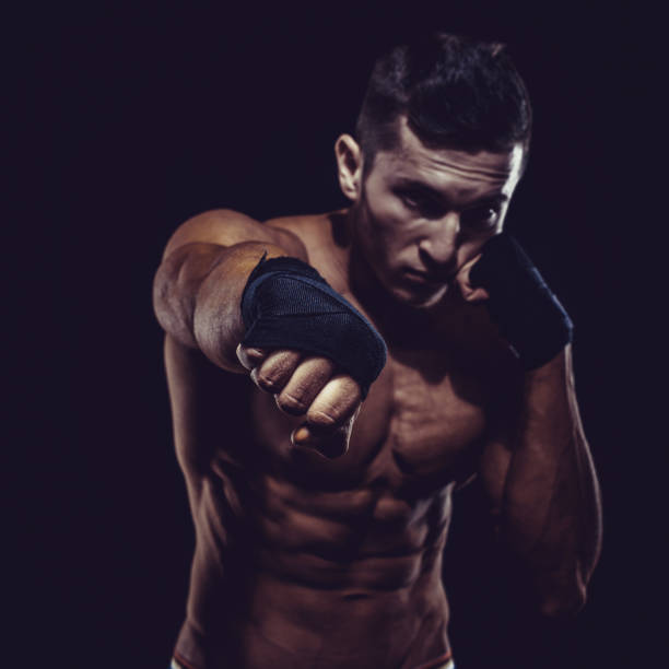 lutador de mma preparando ataduras para treinamento. fundo escuro - kickboxing muay thai exercising sport - fotografias e filmes do acervo
