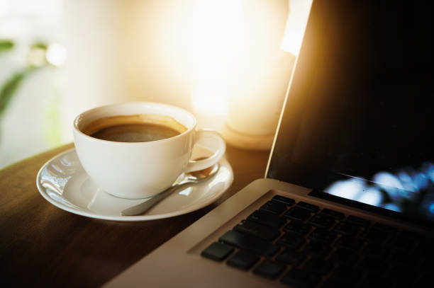 istock Cup of coffee and laptop on wooden table 686964706
