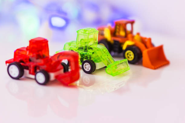 istock Toys red blurred excavator, green loader and blurred  loader, background bokeh. Concept motor skills. 686967806