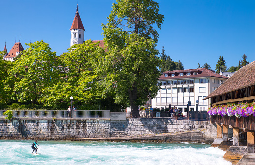 Thun, Switzerland - July 10, 2015:  A surfer performing near the Old Lock of the Aare river