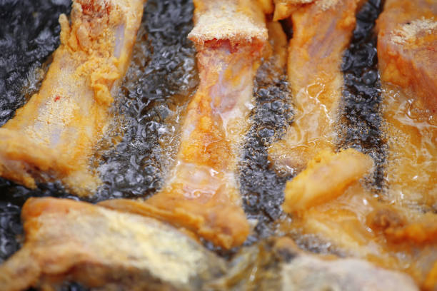 istock Frying pieces of fish on a barbecue pan. 686982962