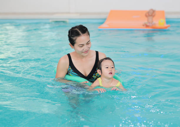 istock Mother teaching kid in swimming pool. 686995370