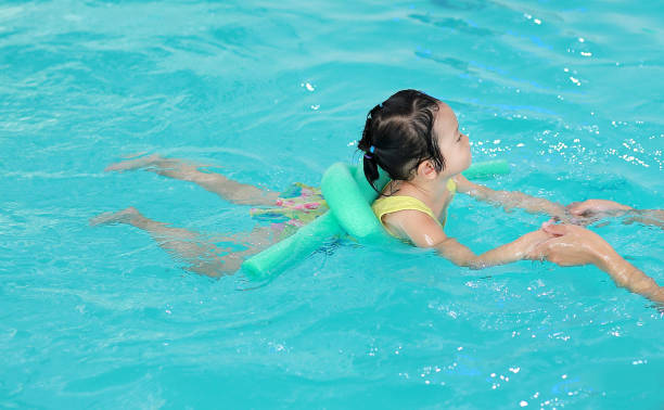 istock Close up mother teaching kid in swimming pool. 686996124