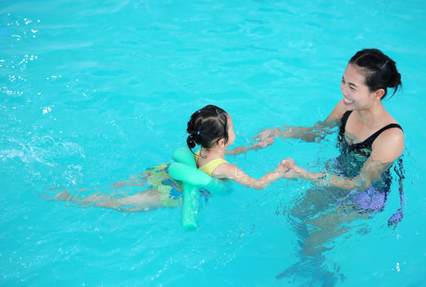 istock Mother teaching kid in swimming pool. 686996536