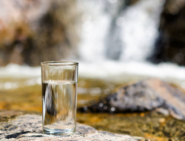 istock Glass of water by waterfall 687006432