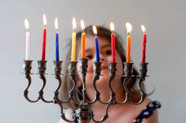 Hanukkah menorah Happy Jewish girl looks at fully lit Hanukkah menorah during the Jewish holiday of Hanukkah. hanukkah candles stock pictures, royalty-free photos & images