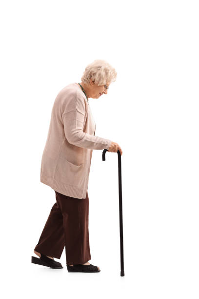 Elderly woman with a walking cane Full length profile shot of an elderly woman with a walking cane isolated on white background walking stick stock pictures, royalty-free photos & images