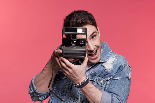 istock portrait of young handsome casual man using vintage camera 687014496