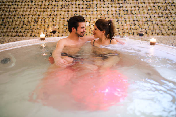 casal romântico relaxante no jacuzzi no spa de saúde. - couple hot tub spa treatment health spa - fotografias e filmes do acervo