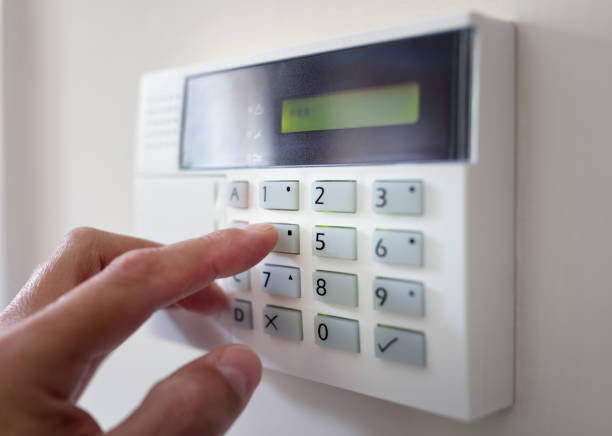 Home or office security Security alarm keypad with person arming the system concept for crime prevention security system stock pictures, royalty-free photos & images