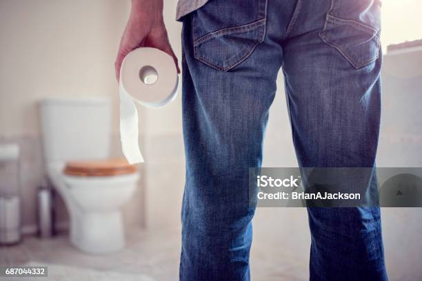 Rollo De Papel De Higiénico De Explotación De Hombre En El Baño Foto de stock y más banco de imágenes de Lavabo - Instalación fija