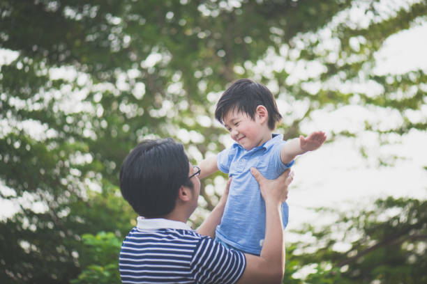 istock Asian father holding his son in the park 687046164