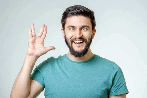 istock Man making Vulcan salute isolated on gray 687046434