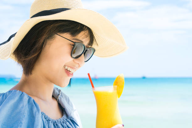 Attractive Woman enjoy mango shake at the Beach.