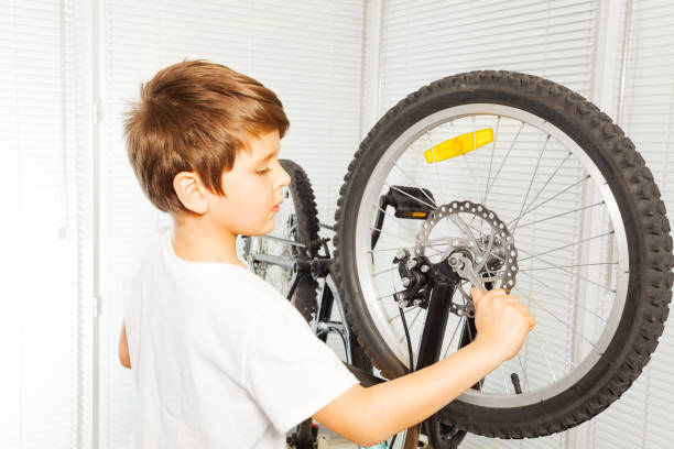 istock Kid boy repairing his bicycle at garage 687067482