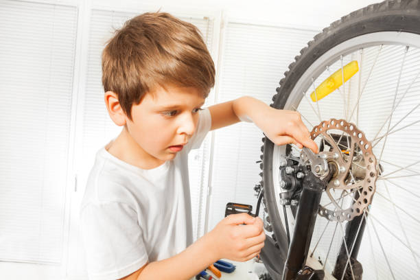 istock Boy repairing bike drawing up a bolt with spanner 687067562