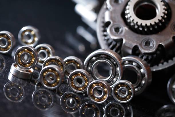 Gears On Dark Machinery concept. Set of various gears and ball bearings on dark background ball bearing photos stock pictures, royalty-free photos & images