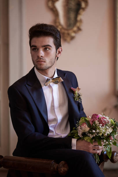 istock young groom waiting his bride on sofa 687071964