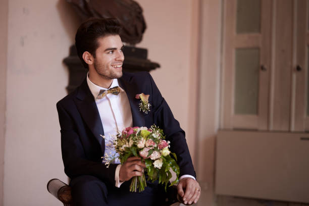 istock young groom waiting his bride on sofa 687072240