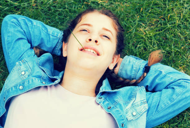 istock portrait of  young female while lying in spring green garden 687082276