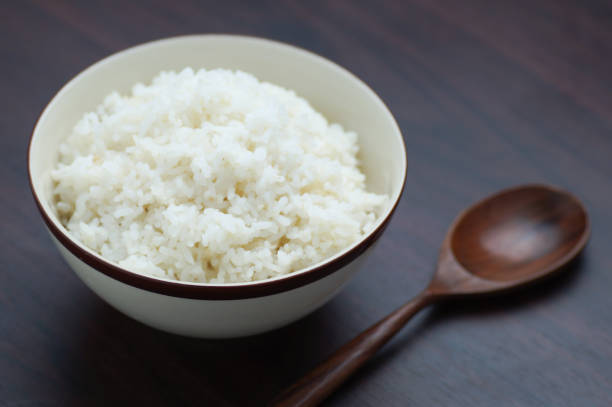 istock Thai rice in bowl with wooden spoon on table 687085048