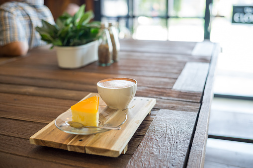 Latte Art con tarta de naranja en mesa de madera. photo