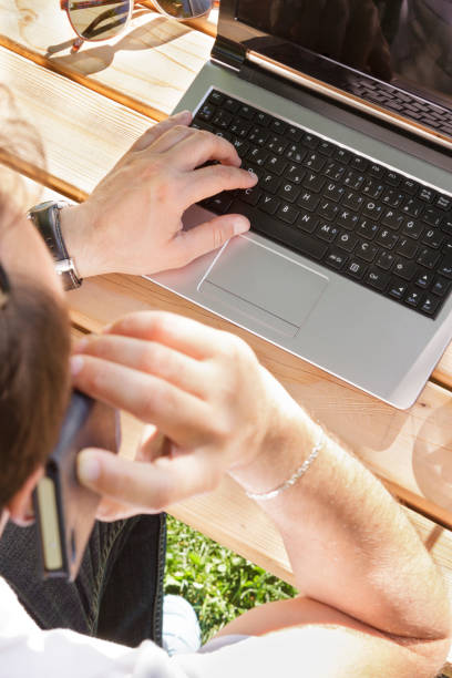 man working in outdoors - surfing wireless vertical outdoors lifestyles imagens e fotografias de stock