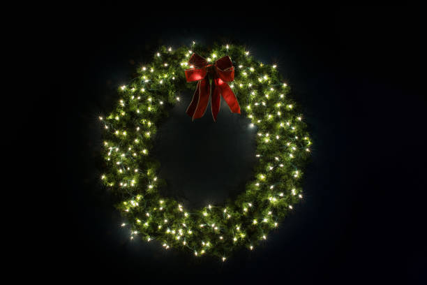 lit christmas wreath on navy wall - christmas lights wreath christmas blue imagens e fotografias de stock