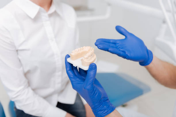 istock Capable clever dentist illustrating his advice 687107040