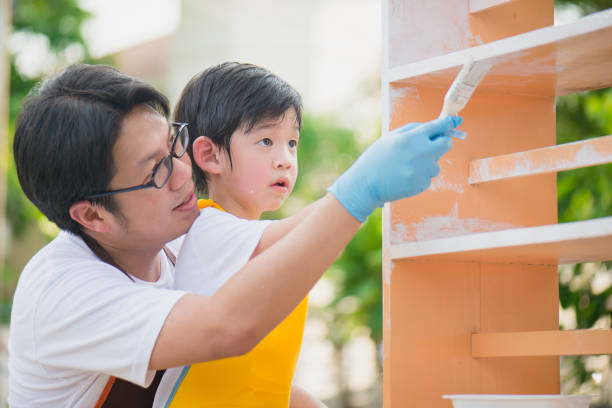 Asian father and son painting wooden shelf together Asian father and son painting wooden shelf together father housework stock pictures, royalty-free photos & images