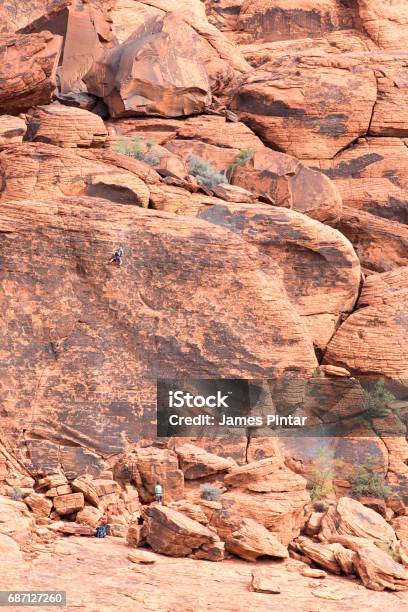 Mountain Climbers Scaling A Red Rock Wall In The Desert Stock Photo - Download Image Now