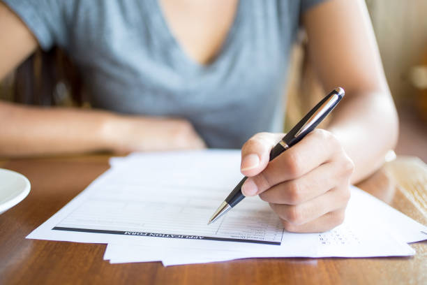istock Close-up of woman filling application form 687128082