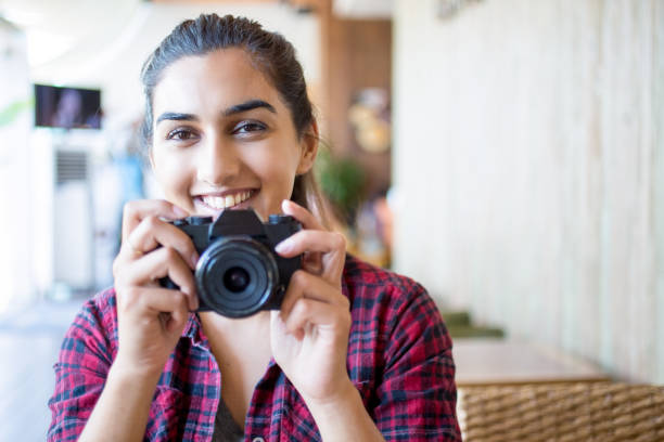 istock Cheerful female photographer posing for camera 687128106